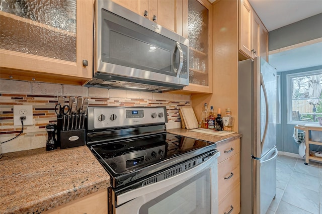 kitchen with glass insert cabinets, stainless steel appliances, and light brown cabinetry