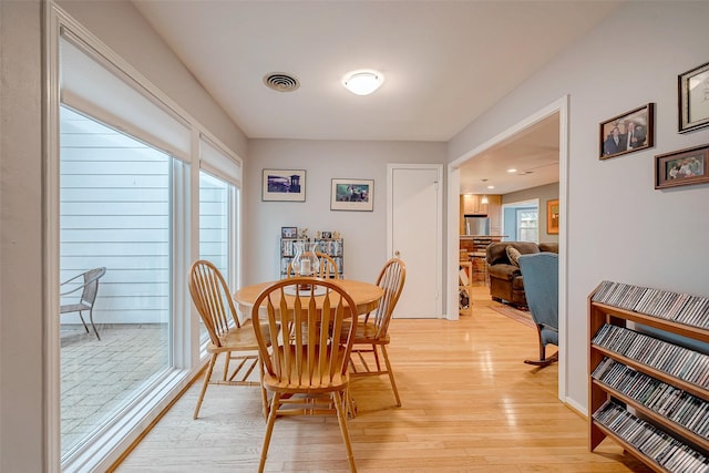 dining area with light wood-style floors and visible vents