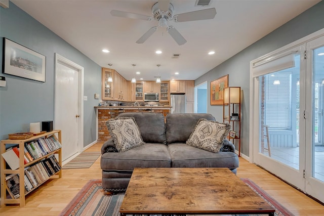 living room featuring baseboards, light wood finished floors, visible vents, and recessed lighting