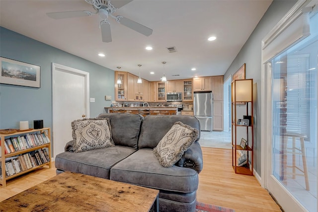 living room with light wood finished floors, visible vents, and recessed lighting