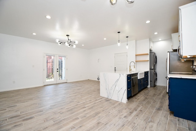 kitchen featuring white cabinetry, open floor plan, appliances with stainless steel finishes, open shelves, and pendant lighting