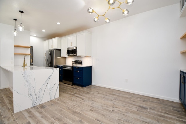 kitchen featuring blue cabinets, a peninsula, stainless steel appliances, white cabinets, and open shelves