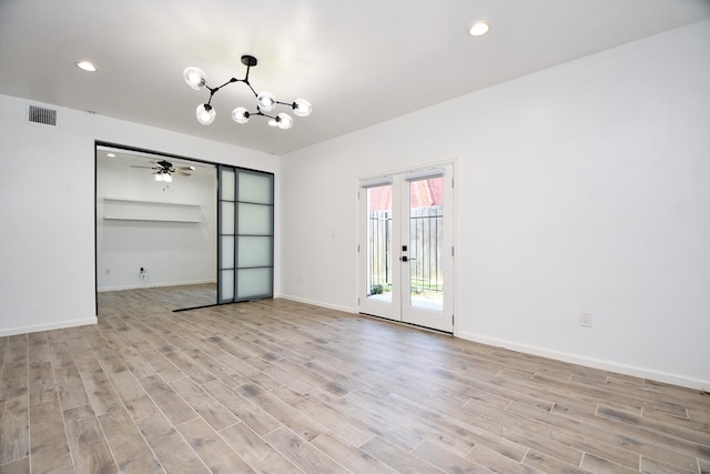 empty room with a chandelier, visible vents, baseboards, light wood-style floors, and french doors