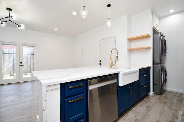 kitchen featuring appliances with stainless steel finishes, blue cabinets, a kitchen island with sink, open shelves, and a sink