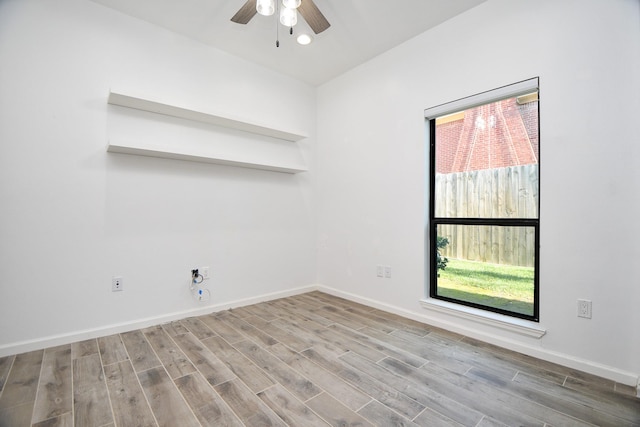 unfurnished room featuring light wood finished floors, a ceiling fan, and baseboards