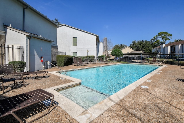 community pool with a residential view, fence, and a patio