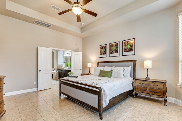 bedroom with a tray ceiling, visible vents, baseboards, and light tile patterned floors