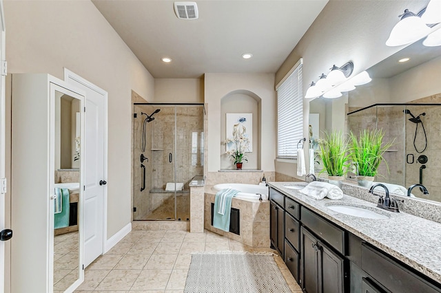 bathroom featuring a bath, a sink, visible vents, and a shower stall