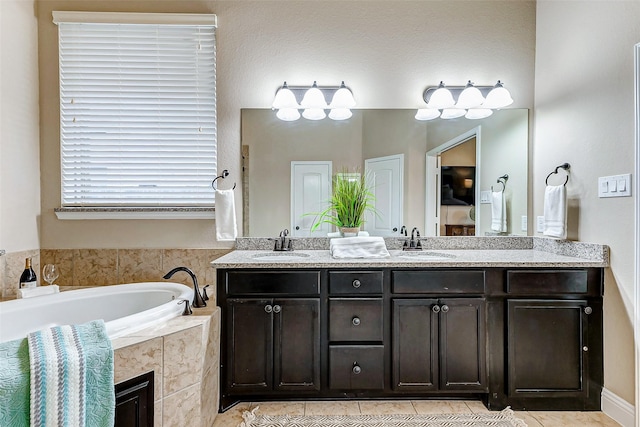 bathroom with tile patterned floors, a sink, a bath, and double vanity