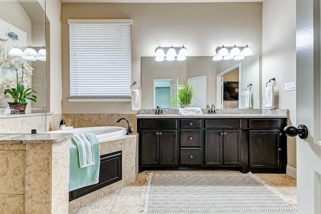 bathroom with a sink, double vanity, tile patterned flooring, and a bath