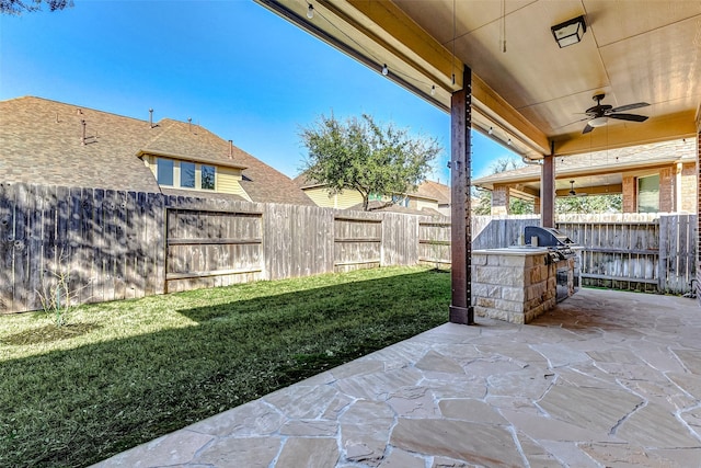 view of patio / terrace featuring ceiling fan, exterior kitchen, and a fenced backyard