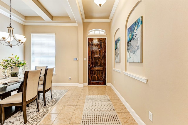 entrance foyer with a chandelier, ornamental molding, light tile patterned flooring, and baseboards