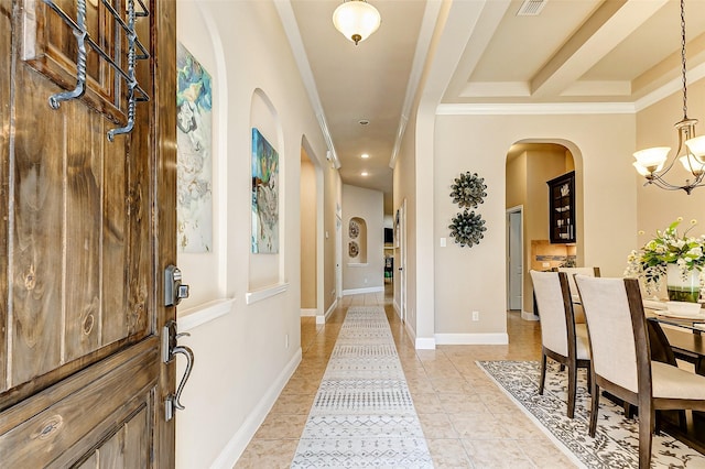 interior space featuring a chandelier, light tile patterned floors, arched walkways, baseboards, and ornamental molding