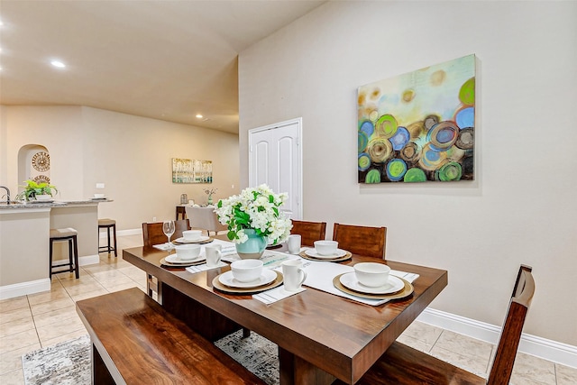 dining area with arched walkways, recessed lighting, baseboards, and light tile patterned floors