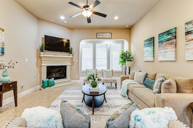 living area with light tile patterned floors, baseboards, a ceiling fan, a glass covered fireplace, and recessed lighting