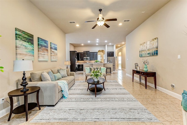 living area with arched walkways, recessed lighting, visible vents, and a ceiling fan