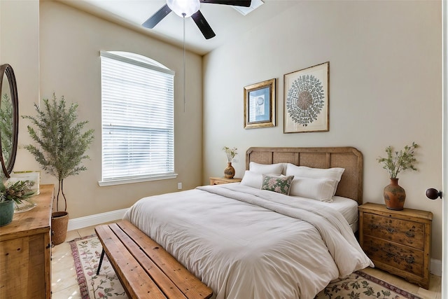 bedroom with light tile patterned flooring, ceiling fan, and baseboards