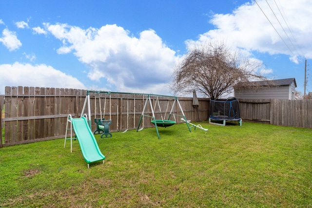 view of jungle gym featuring a trampoline, a fenced backyard, and a yard