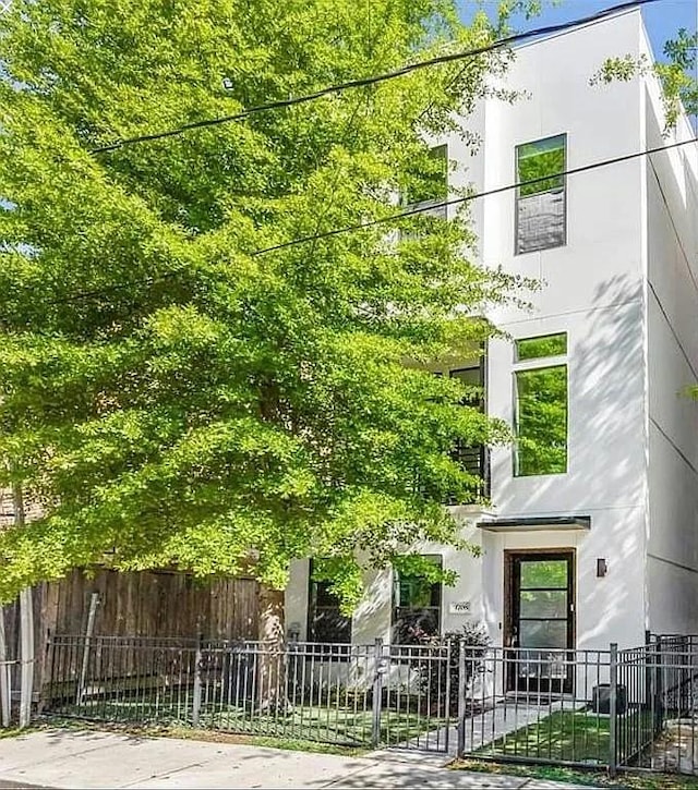 view of front of house featuring a fenced front yard and stucco siding