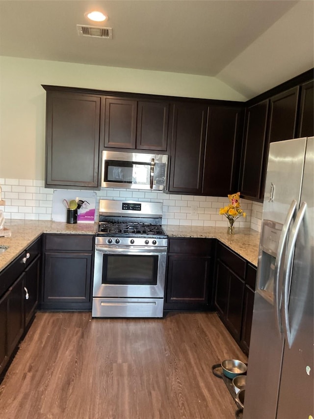 kitchen featuring appliances with stainless steel finishes, tasteful backsplash, visible vents, and dark wood-style floors