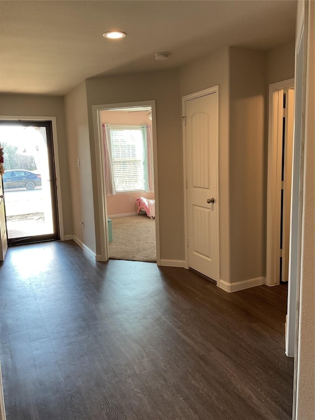 interior space featuring dark wood-type flooring, recessed lighting, and baseboards