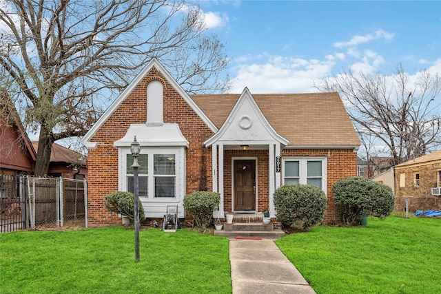 view of front of property featuring brick siding, a front lawn, and fence