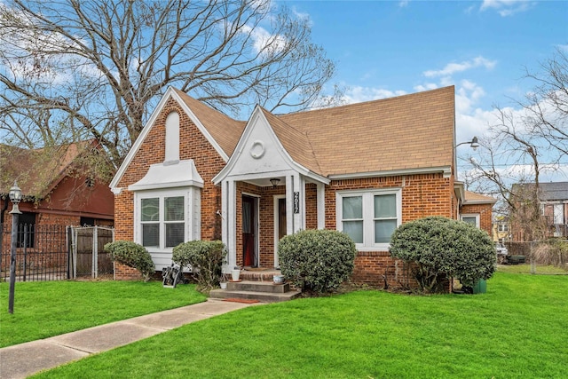 view of front of home with brick siding, fence, and a front lawn