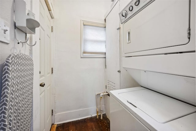 laundry room with dark wood-style floors and stacked washer / dryer