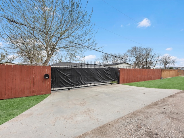 view of gate featuring fence and a lawn