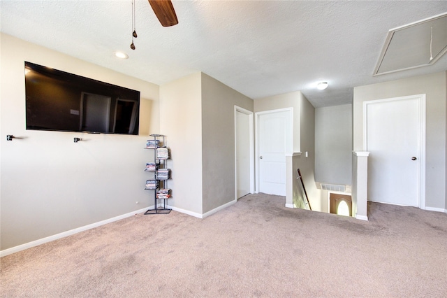 carpeted empty room with attic access, baseboards, and a textured ceiling