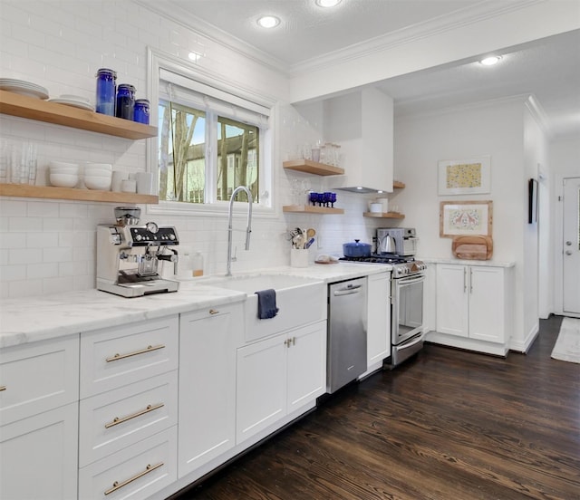 kitchen with white cabinets, light stone counters, stainless steel appliances, open shelves, and a sink