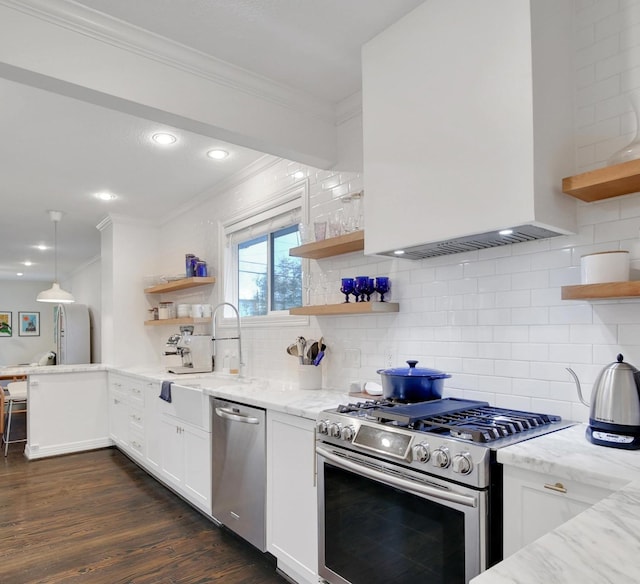 kitchen featuring light stone counters, open shelves, appliances with stainless steel finishes, white cabinetry, and a sink