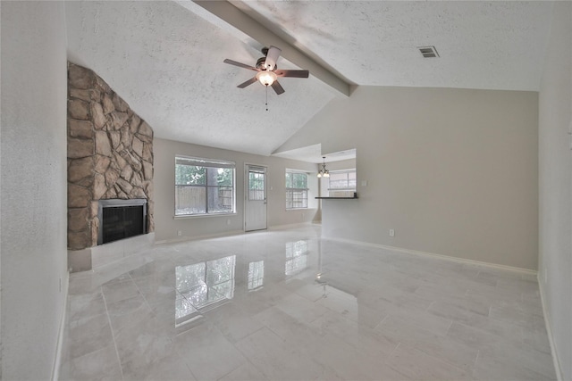 unfurnished living room featuring a fireplace, visible vents, a textured ceiling, and beamed ceiling