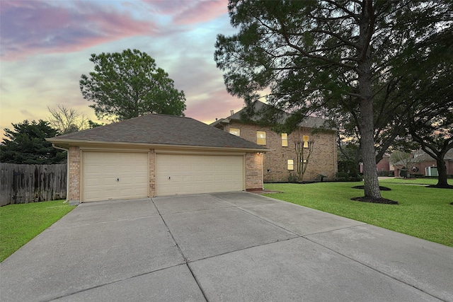 traditional-style home featuring an outbuilding, a garage, brick siding, fence, and a lawn