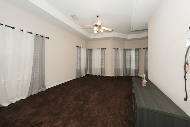 unfurnished bedroom with ceiling fan, carpet floors, a raised ceiling, and visible vents