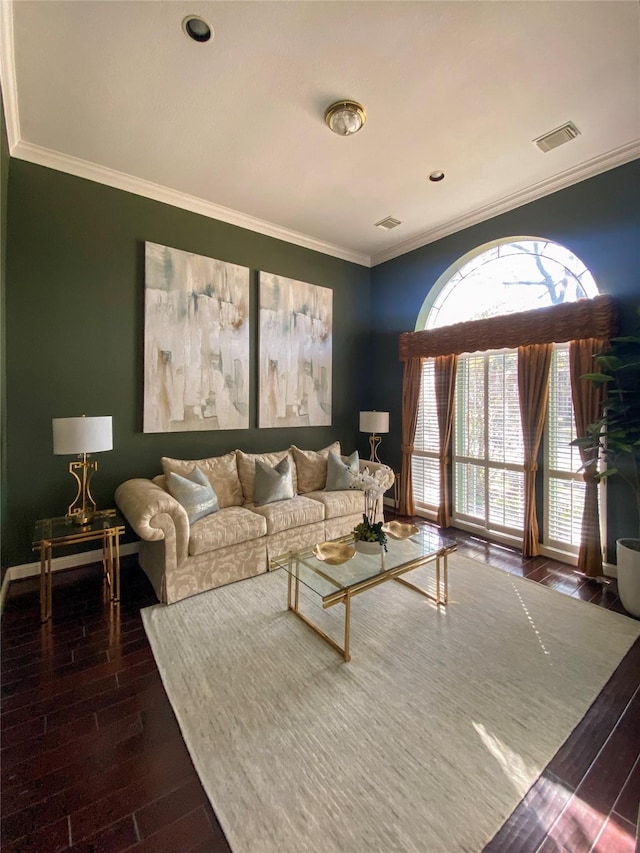 living area with dark wood finished floors, visible vents, crown molding, and baseboards