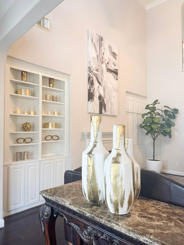 interior details featuring crown molding, visible vents, and wood finished floors