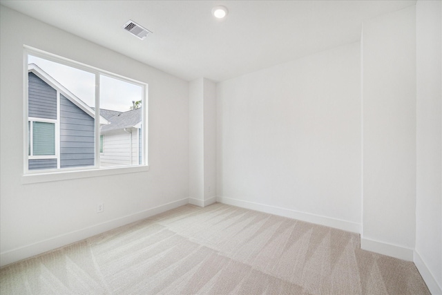 empty room featuring recessed lighting, light colored carpet, visible vents, and baseboards