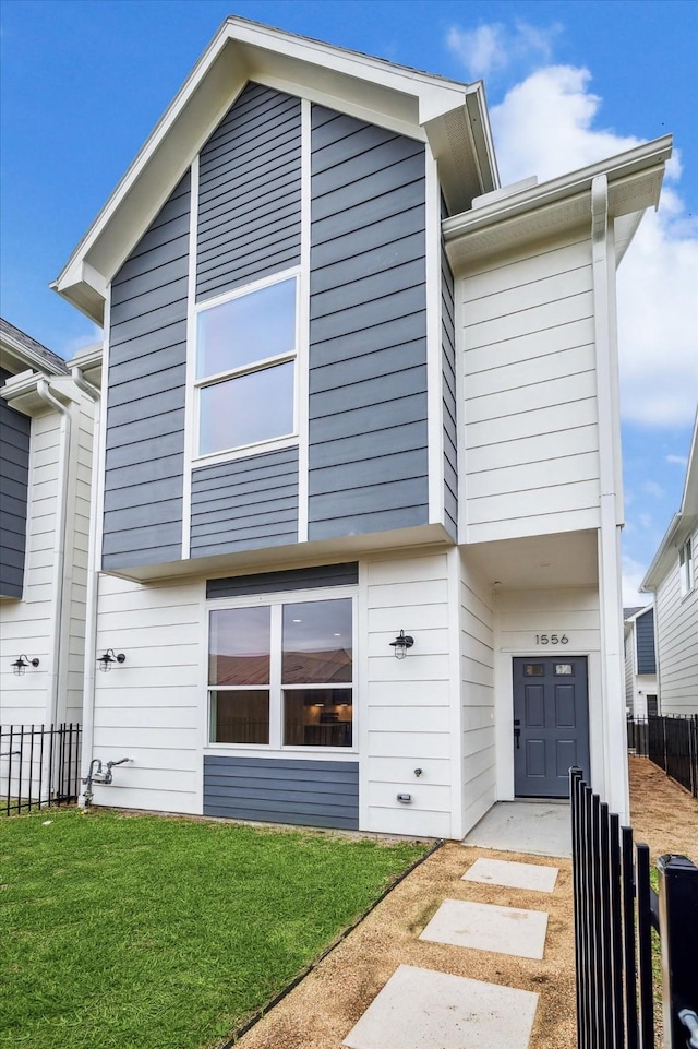 view of front of house featuring a front lawn and fence