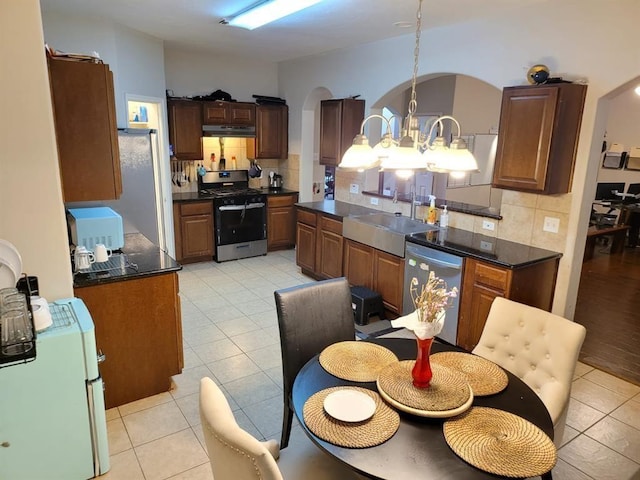 kitchen with stainless steel appliances, dark countertops, and a sink