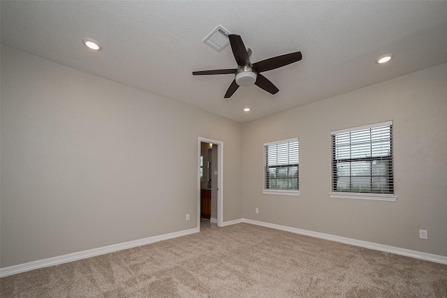 spare room featuring recessed lighting, light colored carpet, visible vents, and baseboards