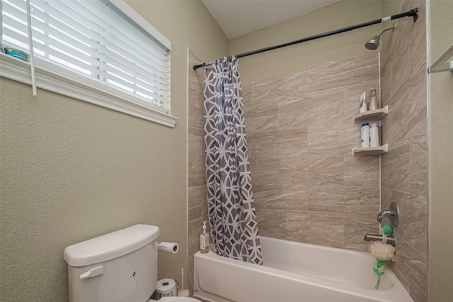 bathroom with shower / bath combination with curtain, a textured wall, and toilet