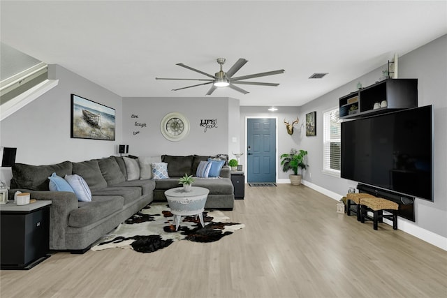 living area with a ceiling fan, visible vents, light wood-style flooring, and baseboards