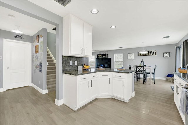 kitchen featuring visible vents, white cabinetry, and dark stone counters