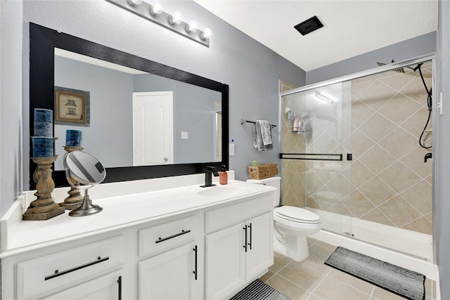 full bath with toilet, a shower stall, vanity, and tile patterned floors