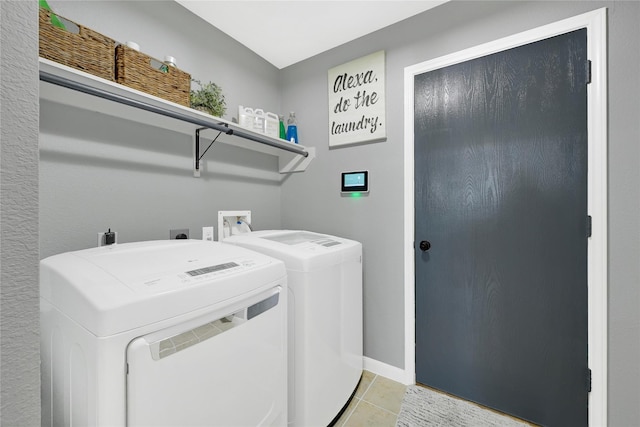 laundry room featuring laundry area, baseboards, separate washer and dryer, and light tile patterned flooring