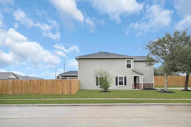 back of property featuring a yard, brick siding, and fence