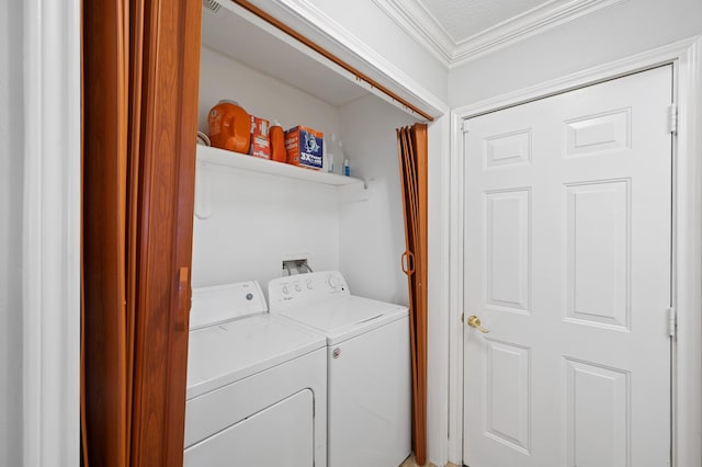 clothes washing area featuring washer and dryer, laundry area, and crown molding