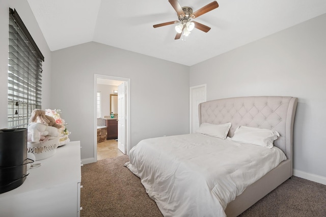 bedroom featuring lofted ceiling, baseboards, carpet flooring, and ensuite bathroom