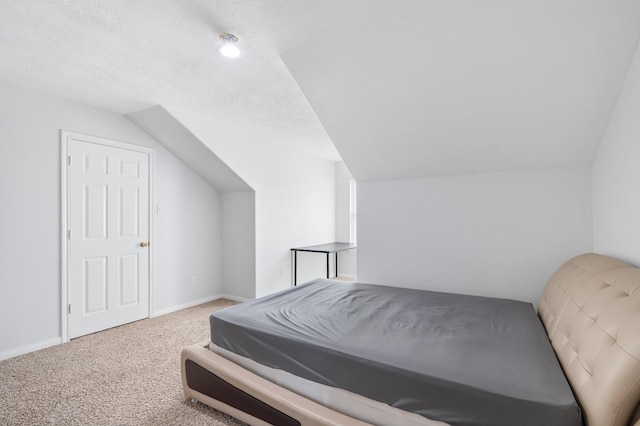 bedroom with lofted ceiling, carpet floors, a textured ceiling, and baseboards